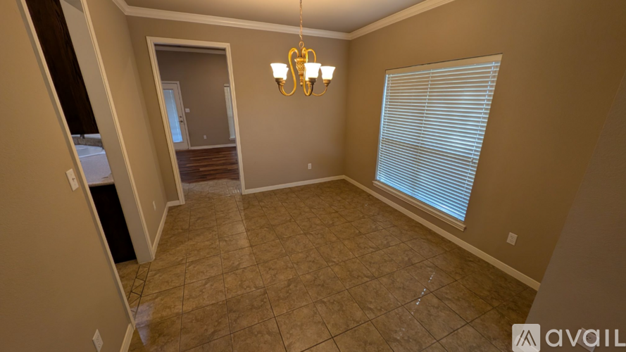 A room with a chandelier and a window with blinds.