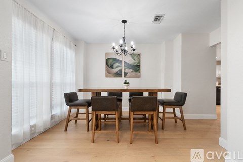 A dining room with a wooden table and chairs.