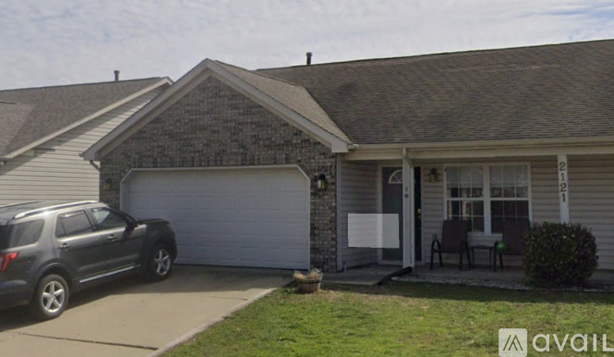 A house with a garage and a car parked in front.