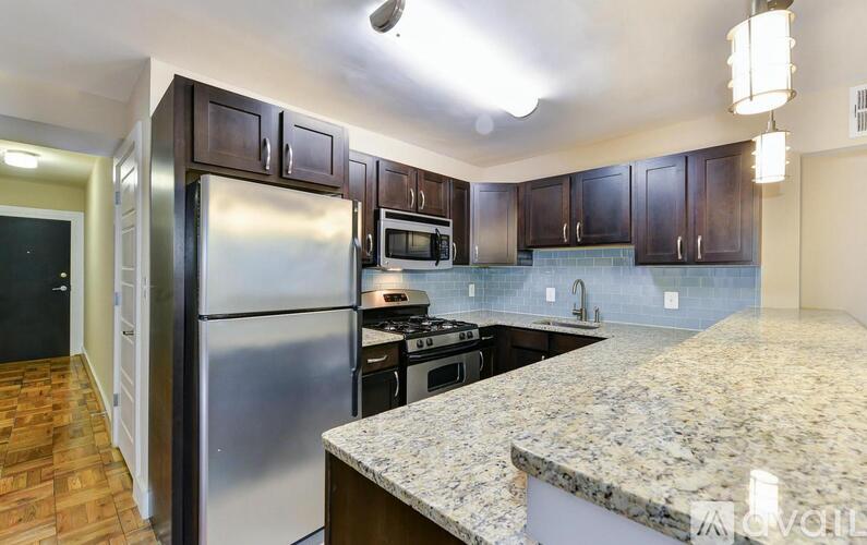 A kitchen with a granite countertop and stainless steel appliances.