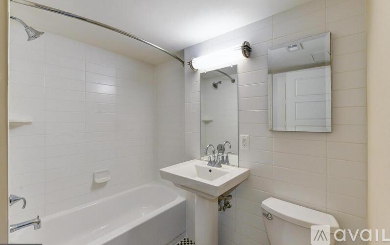 A white bathroom with a tub, sink, and toilet.