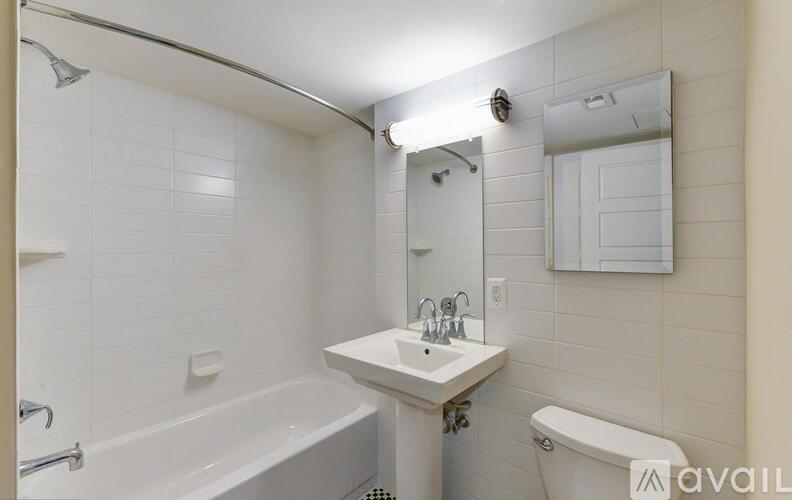 A white bathroom with a tub, sink, and toilet.