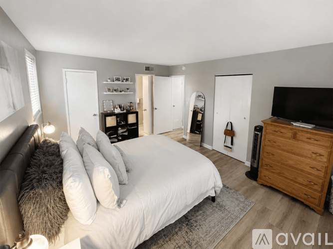 A bedroom with a large bed, a couch, and a TV.