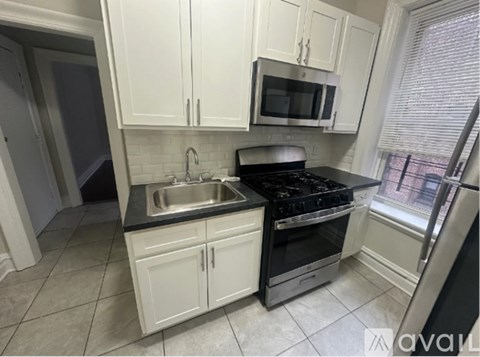 A kitchen with white cabinets and black appliances.