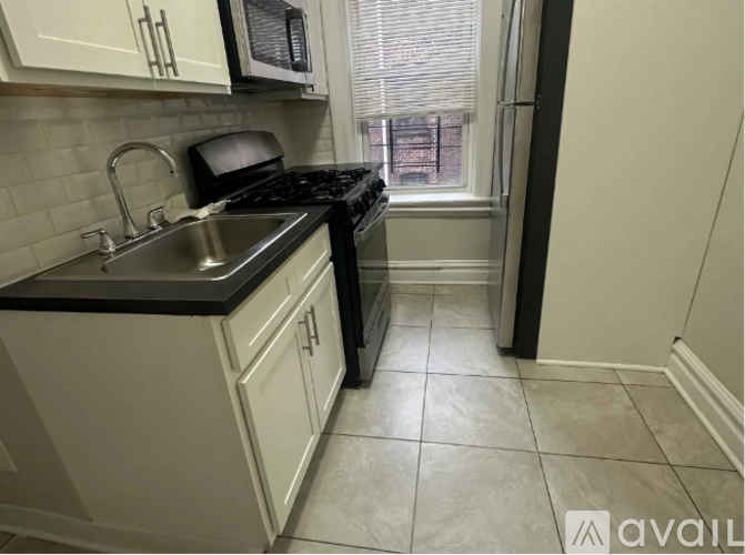 A kitchen with black countertops and white cabinets.