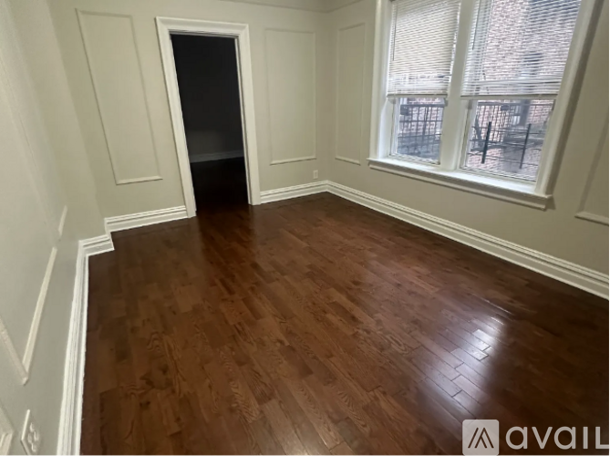 A room with wooden flooring and white walls.