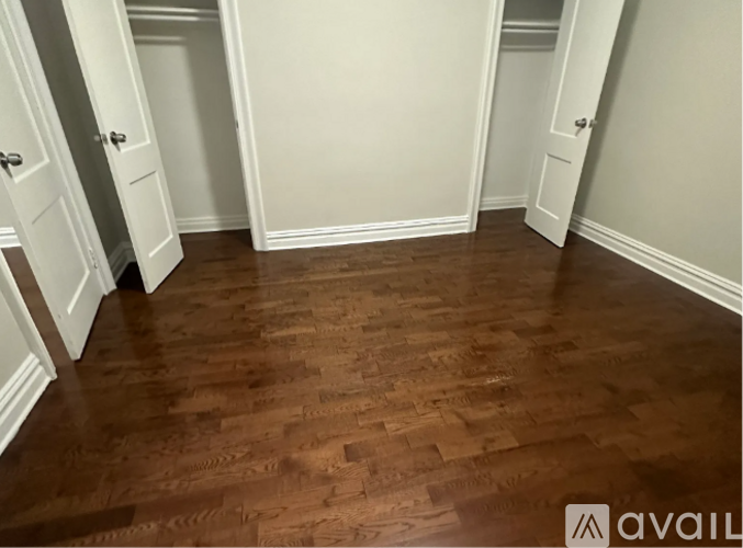 A room with wooden flooring and white walls.