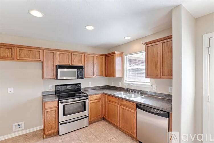 A kitchen with wooden cabinets and stainless steel appliances.