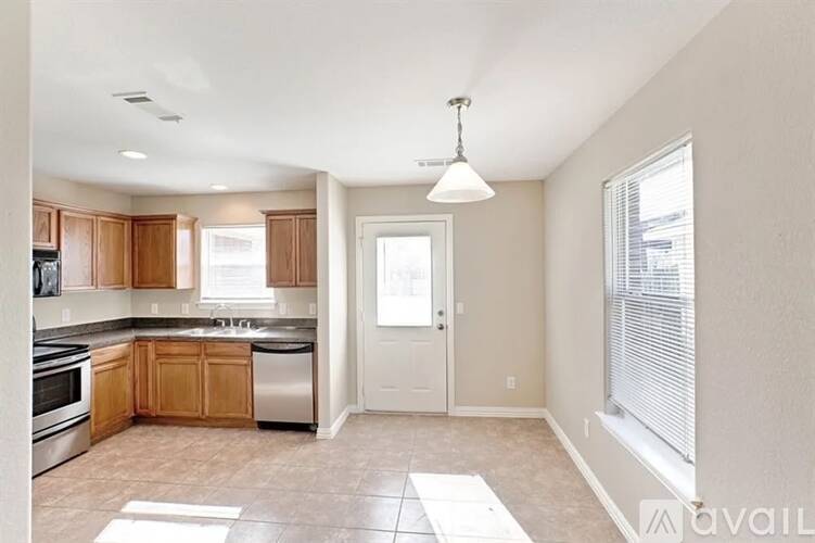 A kitchen with wooden cabinets and a white door.