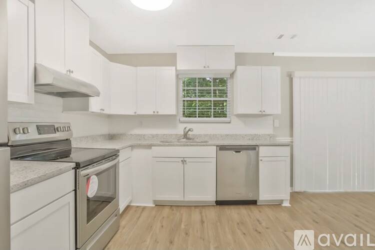 A spacious room with a ceiling fan and carpeted floor.