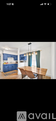 A kitchen with blue cabinets and a wooden table.