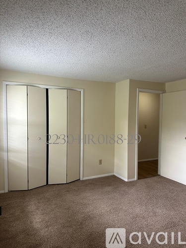 A room with a carpeted floor and a wall with a number and a symbol on it.
