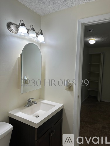 A bathroom with a sink, mirror, and lights.