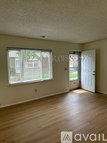 A room with a door and a window with blinds.