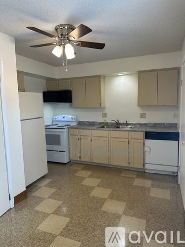 A kitchen with a checkered floor and a ceiling fan.