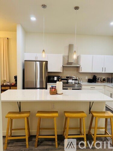 A kitchen with white countertops and yellow stools.