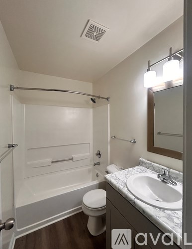 A bathroom with a toilet, sink, and shower.