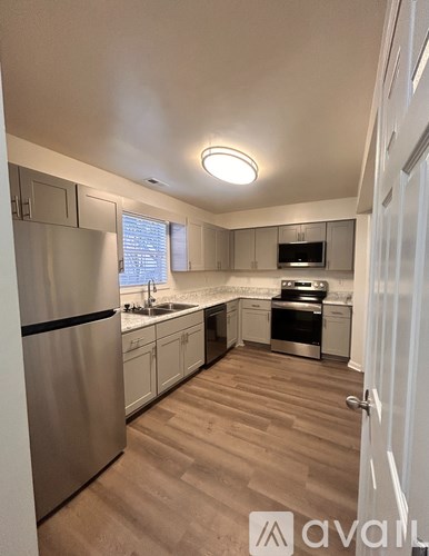 A kitchen with a refrigerator, sink, and stove.