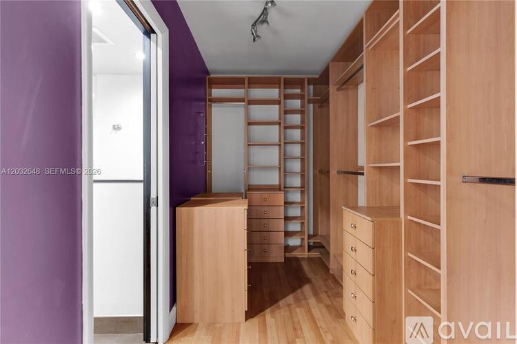 A room with wooden furniture and a purple wall.