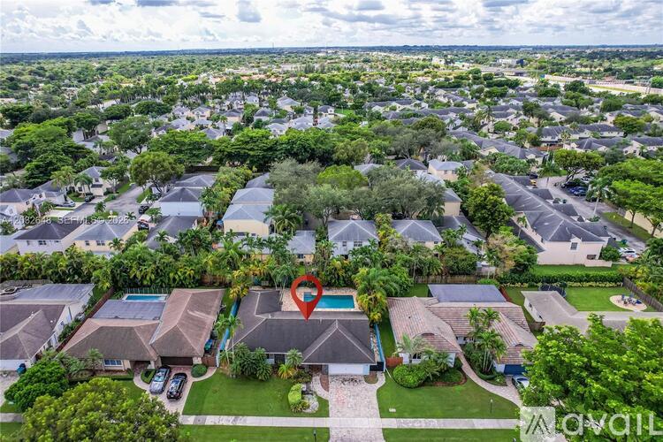 A bird's eye view of a residential area with a swimming pool in the foreground.