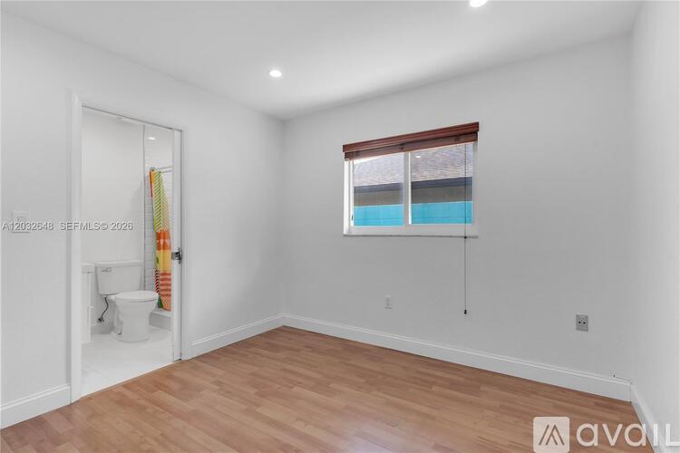 A room with a toilet and a window.