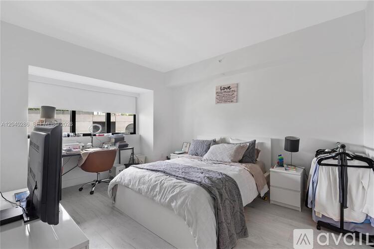 A bedroom with a bed, desk, and chair.