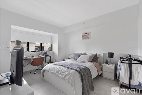 A bedroom with a bed, desk, and chair.