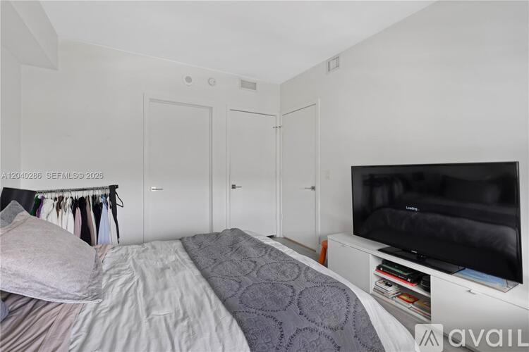 A bedroom with a bed, a television, and a closet.