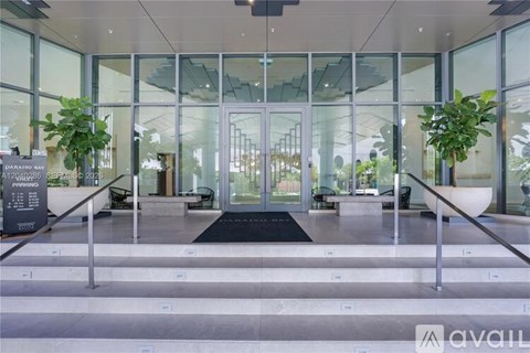 A glass door entrance with a black mat in front.