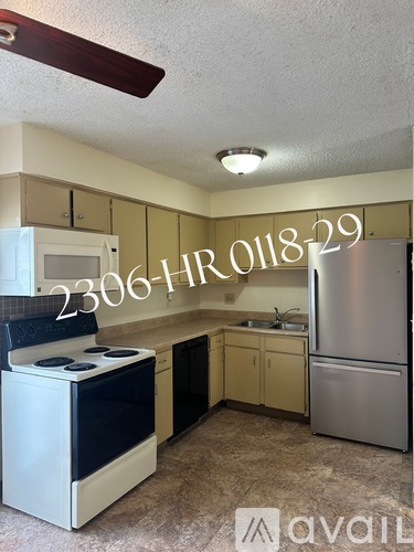A kitchen with a stove, sink, and refrigerator is available for rent.