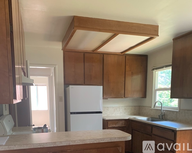 A kitchen with wooden cabinets and a white fridge.