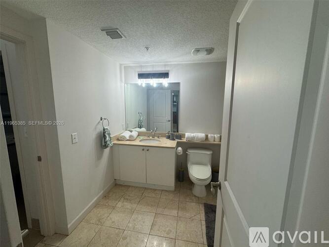 A bathroom with a toilet, sink, and mirror.
