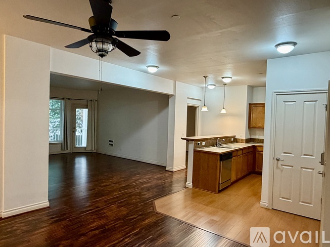 A spacious room with a ceiling fan and pendant lights.