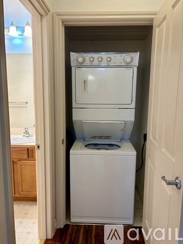 A white washer and dryer stacked on top of each other in a small laundry room.
