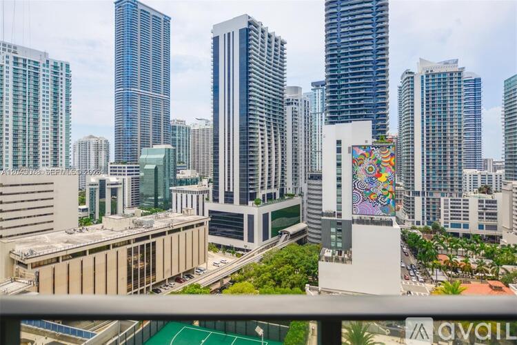 A cityscape with a variety of buildings, including a tall skyscraper with a colorful mural on the side.