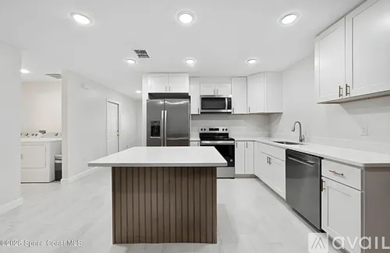 A modern kitchen with white cabinets and a central island.