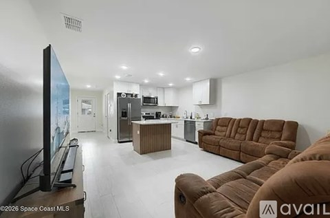 A living room with a brown couch and a flat screen TV.
