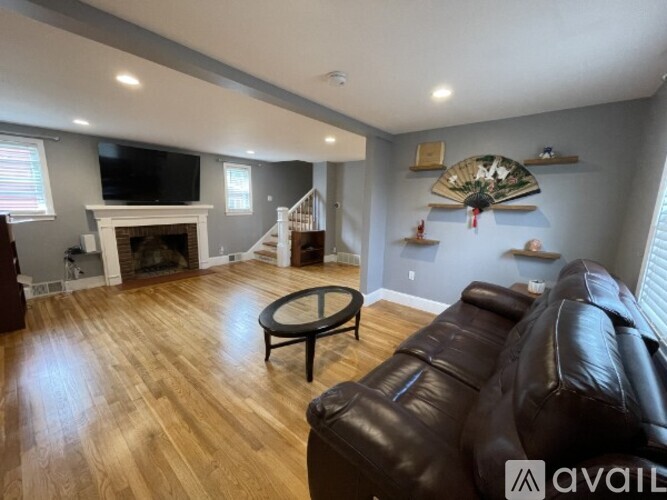 A living room with a fireplace and a TV on the wall.