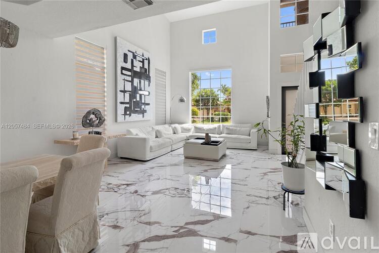 A modern living room with a marble floor and white furniture.