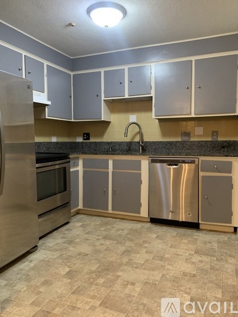 A kitchen with a stainless steel refrigerator and a sink.