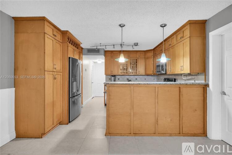 A kitchen with wooden cabinets and a refrigerator.