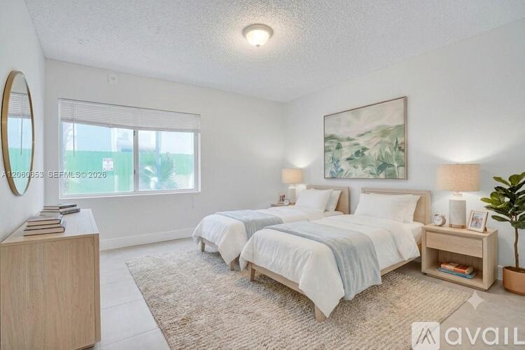 A bedroom with two beds, a nightstand, and a plant.