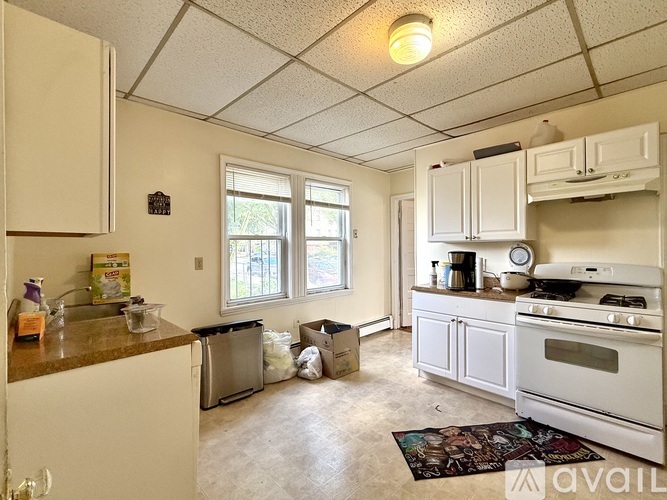 A kitchen with white appliances and cabinets is available for rent.