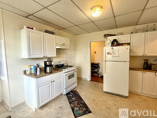A kitchen with white appliances and cabinets.