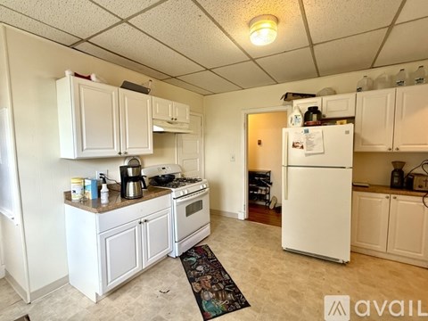 A kitchen with white appliances and cabinets.