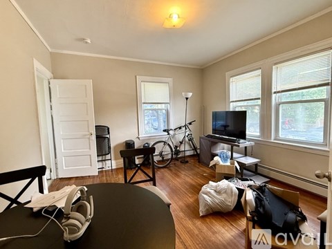A living room with a TV, a bicycle, and a table with headphones on it.