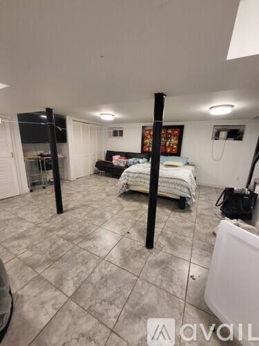 A room with a bed, a fridge, and a TV.
