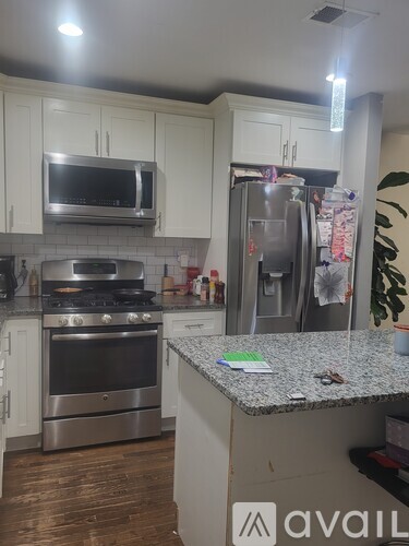 A kitchen with a granite countertop and stainless steel appliances.