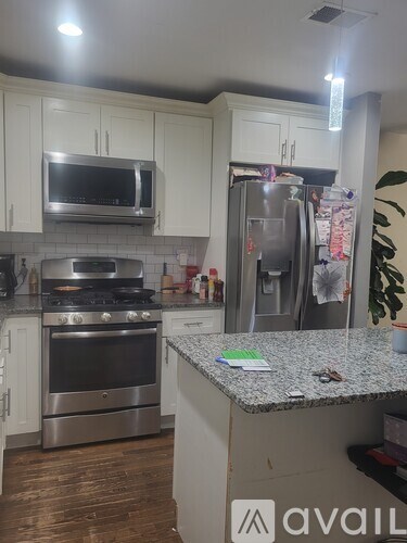 A kitchen with a granite countertop and stainless steel appliances.