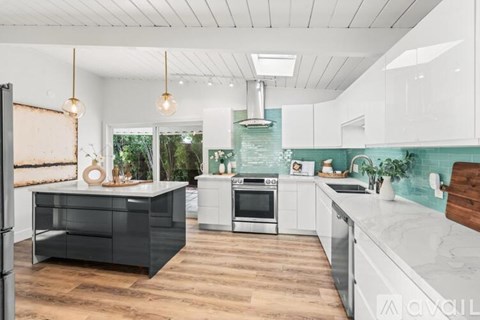 A modern kitchen with a black drawer unit and a white countertop.